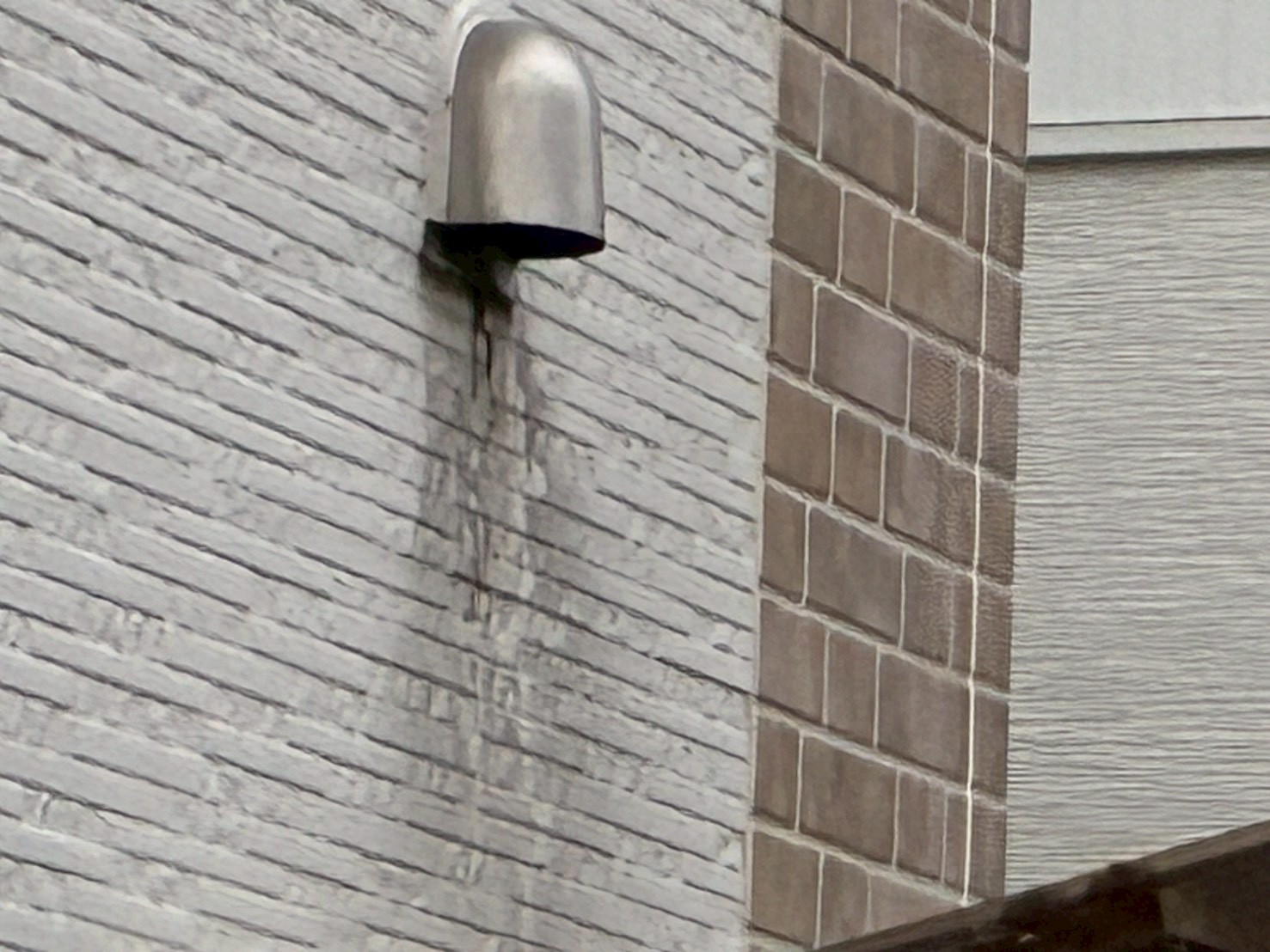 外部フードの雨垂れで黒く汚れた外壁